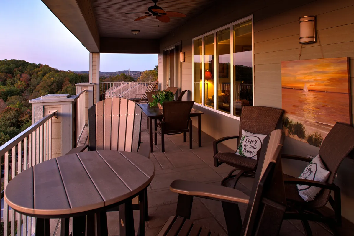 A tranquil outdoor seating area overlooking Table Rock Lake, with comfortable chairs positioned to face the sunset. The scene bathes in warm evening light, inviting guests to relax, sip beverages, and engage in intimate conversation as the sun sets beyond the water.