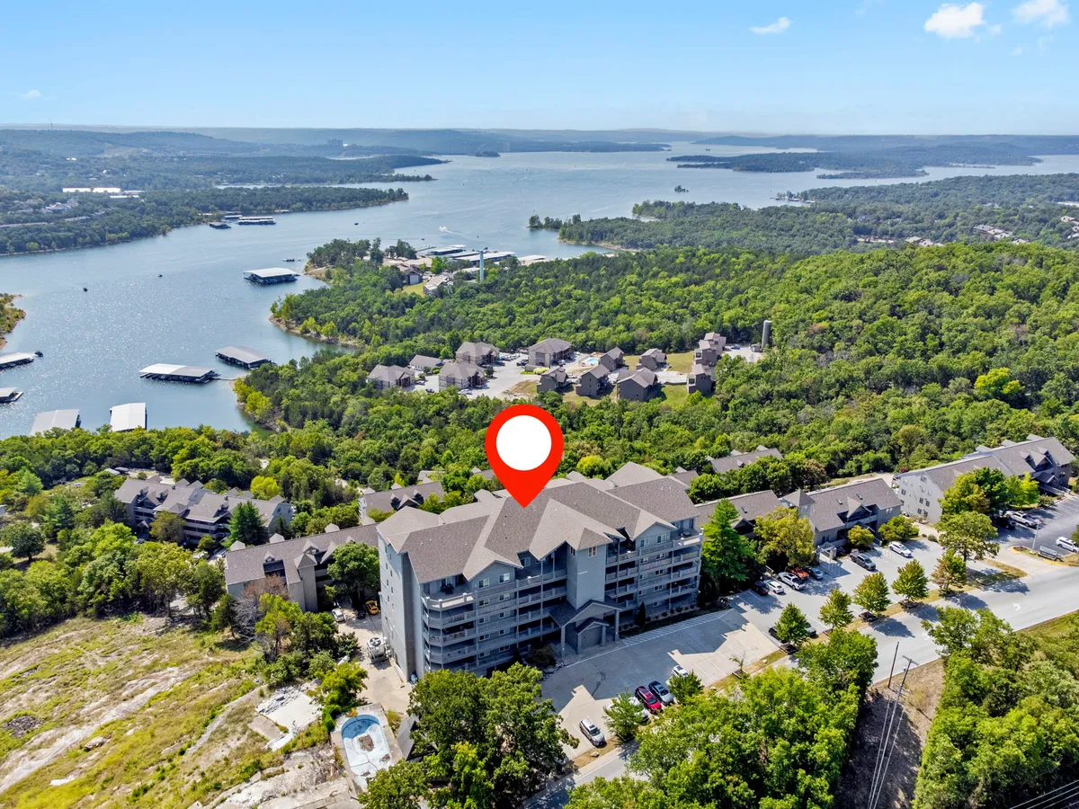 A serene exterior view showing the lake surrounded by lush greenery, with the building structure subtly visible. The scene suggests opportunities for outdoor recreation or simply soaking in peaceful nature—the perfect backdrop for a romantic getaway.